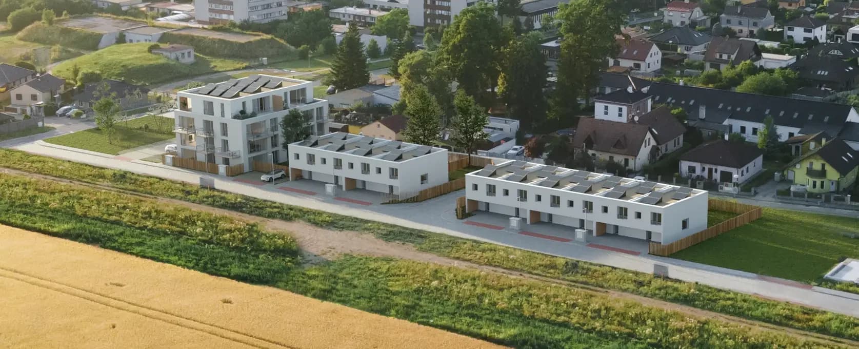 Letecký pohled na areál – bytový dům a dva bloky řadových domů v ulici Jana Zajíce